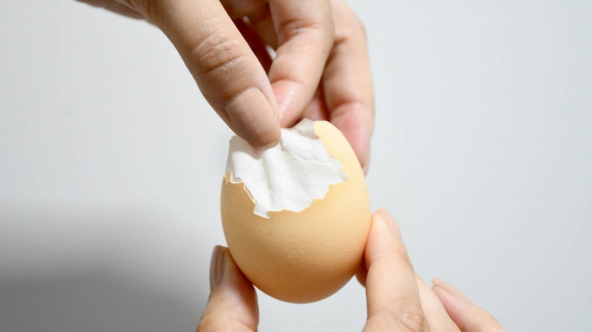 Infographic comparing hand-cracking vs. using an egg cracker tool showing 92% fewer shell fragments